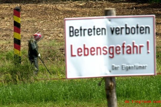 
Ein Mann mit me<em></em>talldetektor und Schutzkleidung sucht im Jahr 2001 an der ehemaligen deutsch-deutschen Grenze bei Behrungen nach Bodenminen
