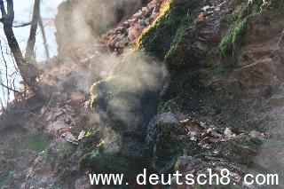 Rauchschwaden steigen aus den Felsspalten des Brennenden Berges in Dudweiler